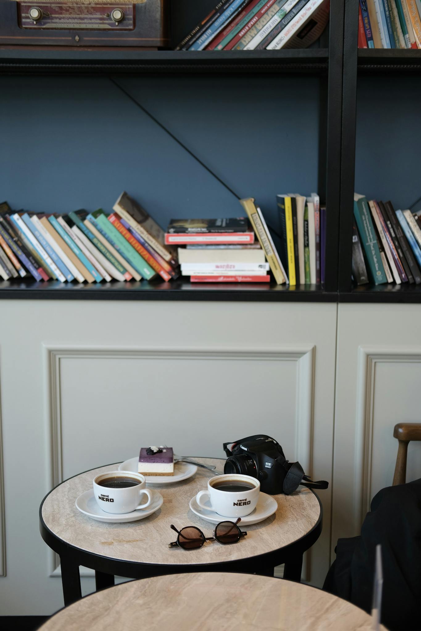Inviting library scene featuring coffee cups, a table with books, and a bookshelf.